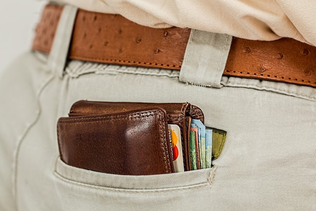 Un portafoglio con soldi e carte di credito nella tasca posteriore di un pantalone